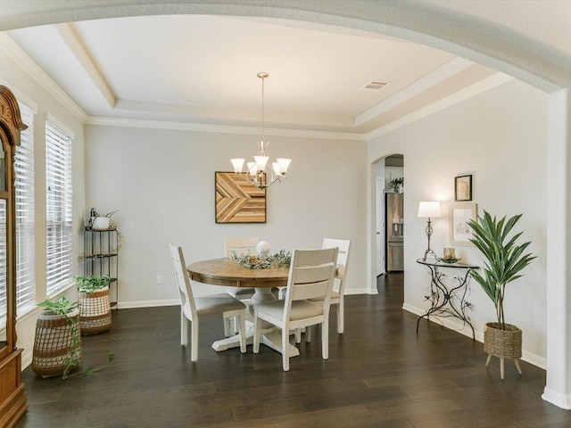 2733 Painted Sky Bnd, Leander, TX 78641 - dining area featuring arched walkways, a raised ceiling, wood finished floors, a chandelier, and ornamental molding