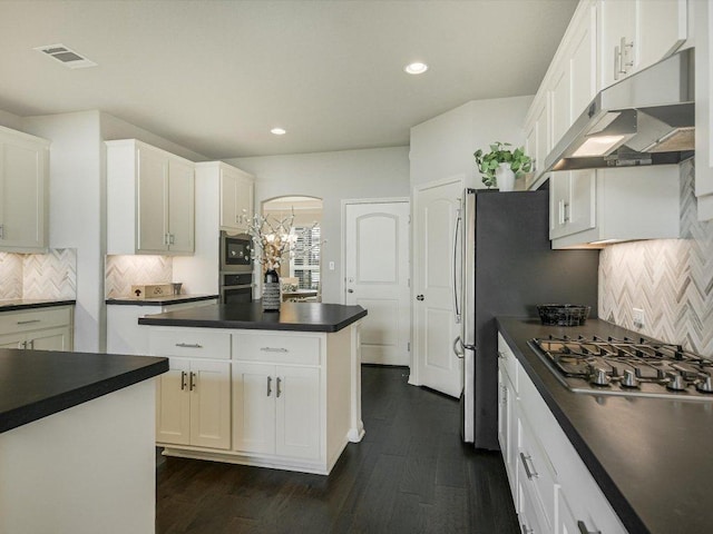 2733 Painted Sky Bnd, Leander, TX 78641 - kitchen with under cabinet range hood, dark countertops, appliances with stainless steel finishes, recessed lighting, and dark wood finished floors