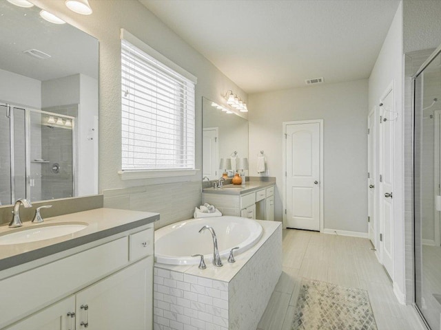 2733 Painted Sky Bnd, Leander, TX 78641 - bathroom featuring a stall shower, two vanities, and a garden tub