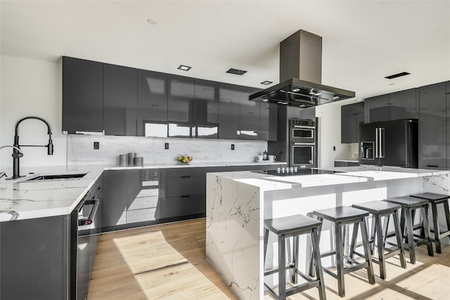 1903 Toro Canyon Rd, Austin, TX 78746 - kitchen featuring island range hood, high end fridge, modern cabinets, and a breakfast bar area