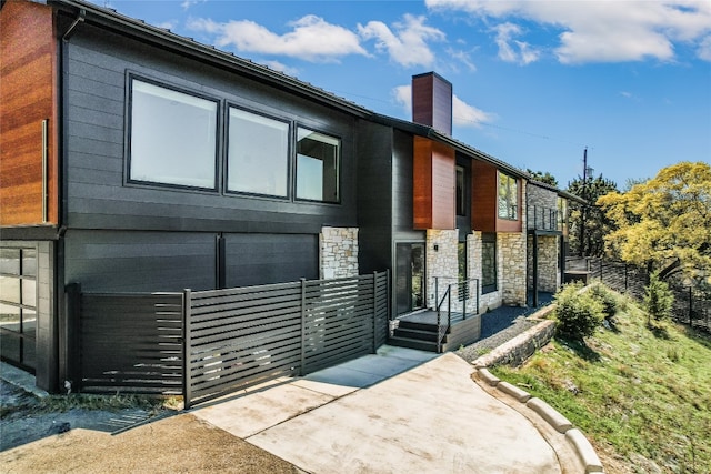 1903 Toro Canyon Rd, Austin, TX 78746 - view of front of house with stone siding and a chimney