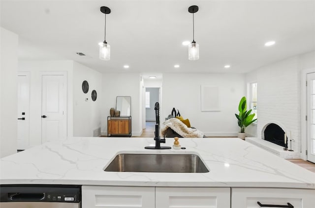 6014 London Dr, Austin, TX 78745 - kitchen with a sink, open floor plan, dishwasher, white cabinets, and light stone counters
