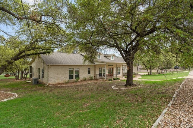 21507 Lakefront Dr, Lago Vista, TX 78645 - back of house featuring a yard, roof with shingles, stone siding, and central AC