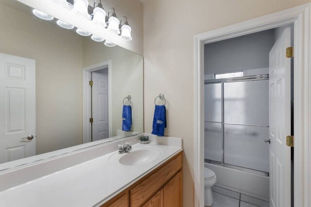 21507 Lakefront Dr, Lago Vista, TX 78645 - full bathroom featuring toilet, vanity, shower / bath combination with glass door, and tile patterned floors