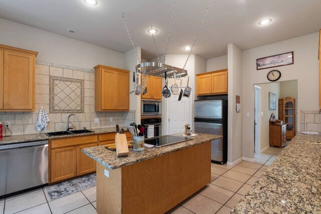 21507 Lakefront Dr, Lago Vista, TX 78645 - kitchen featuring appliances with stainless steel finishes, a sink, decorative backsplash, a kitchen island, and recessed lighting