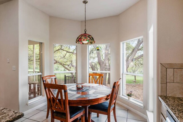 21507 Lakefront Dr, Lago Vista, TX 78645 - dining room with healthy amount of natural light, light tile patterned flooring, a towering ceiling, and baseboards