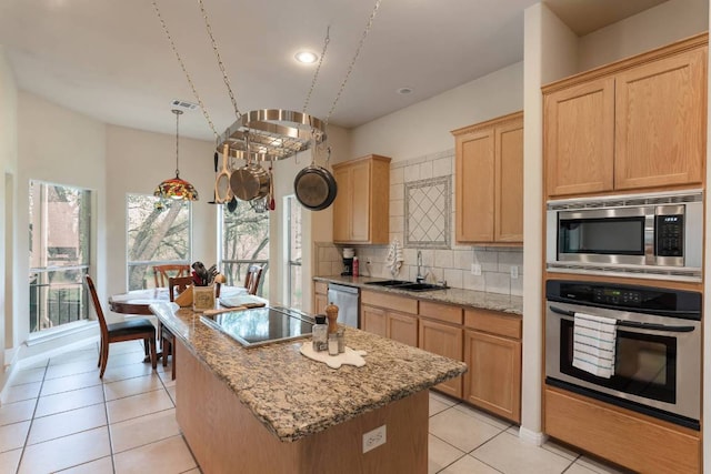 21507 Lakefront Dr, Lago Vista, TX 78645 - kitchen featuring stainless steel appliances, a sink, a center island, backsplash, and light stone counters