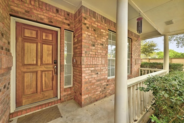 13401 Lamplight Village Ave, Austin, TX 78727 - doorway to property featuring covered porch and brick siding