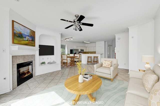 13401 Lamplight Village Ave, Austin, TX 78727 - living area with light tile patterned floors, a ceiling fan, a fireplace, and rail lighting