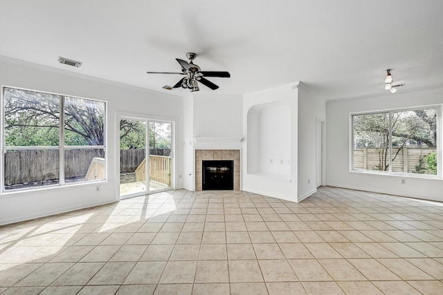 13401 Lamplight Village Ave, Austin, TX 78727 - unfurnished living room featuring light tile patterned flooring, a tiled fireplace, ceiling fan, ornamental molding, and baseboards