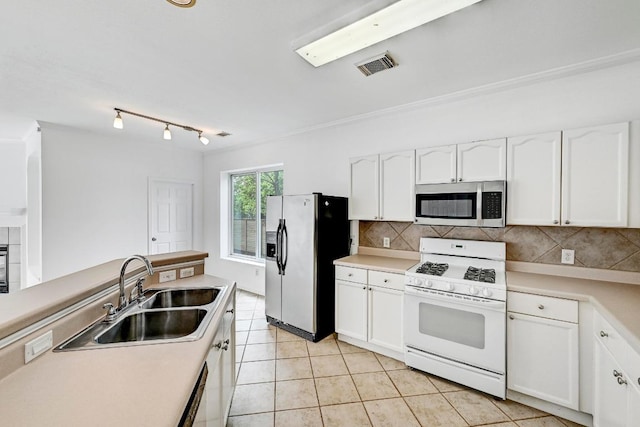 13401 Lamplight Village Ave, Austin, TX 78727 - kitchen featuring appliances with stainless steel finishes, a sink, white cabinetry, tasteful backsplash, and ornamental molding