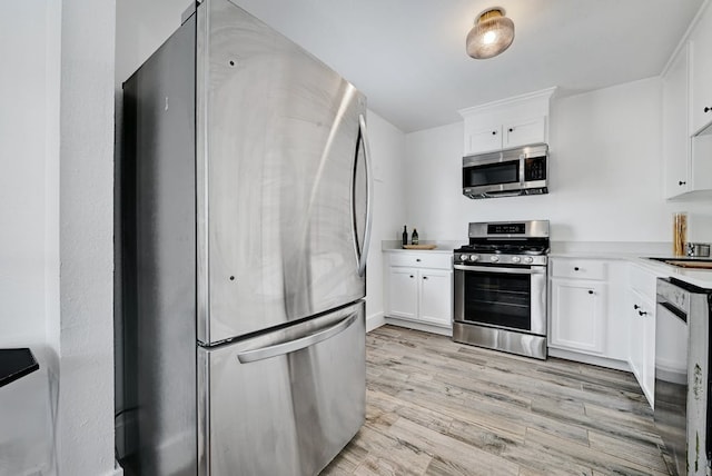 5313 Martin Ave, Austin, TX 78751 - kitchen featuring stainless steel appliances, light wood-style flooring, and white cabinets