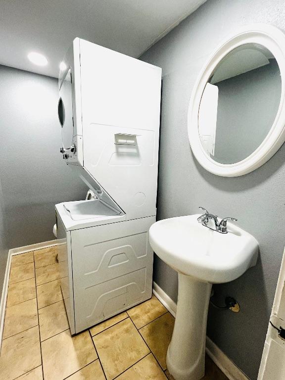 6501 E Hill Dr Unit 105, Austin, TX 78731 - bathroom featuring stacked washer and clothes dryer and tile patterned flooring