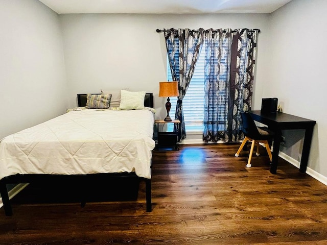 bedroom featuring wood finished floors and baseboards