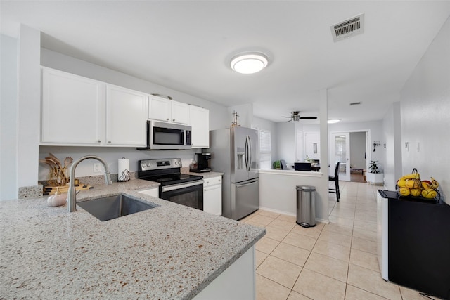 12404 Granton Cv, Austin, TX 78754 - kitchen with light stone counters, a sink, light tile patterned floors, appliances with stainless steel finishes, and visible vents