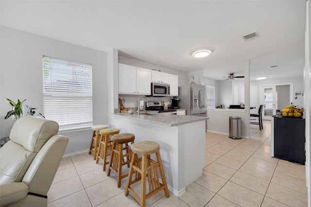 12404 Granton Cv, Austin, TX 78754 - kitchen with stainless steel appliances, visible vents, light tile patterned floors, a peninsula, and open floor plan