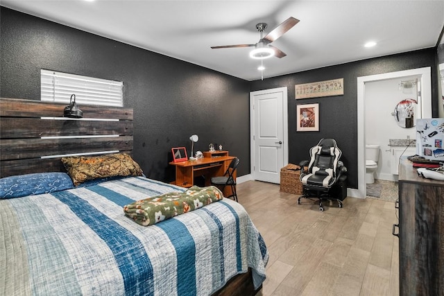 1241 Lake Terrace Dr, Elgin, TX 78621 - bedroom featuring baseboards, a textured wall, ensuite bathroom, a ceiling fan, and wood finished floors