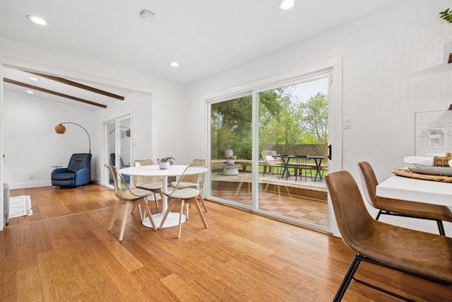 dining room with light wood-style floors, recessed lighting, baseboards, and beamed ceiling