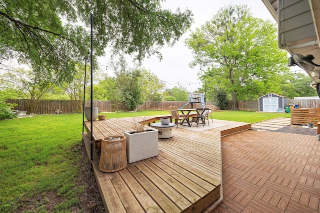 deck with a storage unit, an outdoor structure, and outdoor dining space