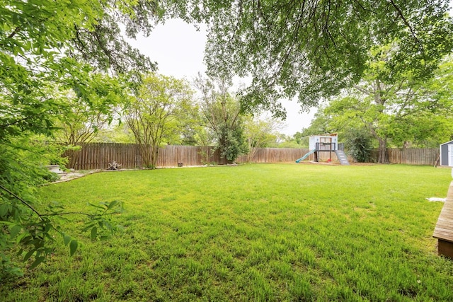 view of yard with a playground, a shed, and an outbuilding