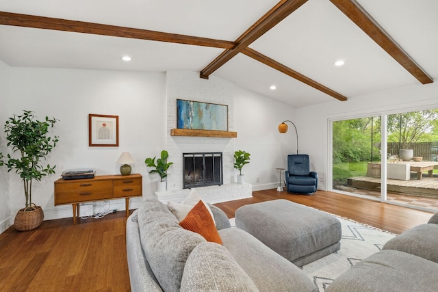 living area with wood finished floors, a brick fireplace, baseboards, and recessed lighting