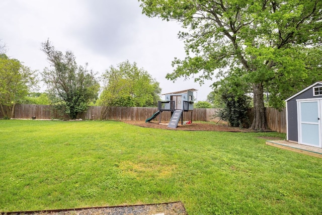 view of yard featuring a playground, a shed, and an outdoor structure