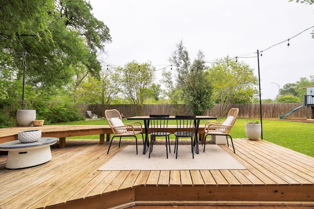 deck featuring a playground and outdoor dining space