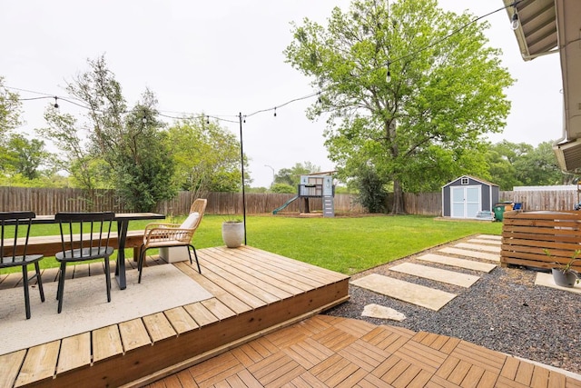 deck with a playground, a storage shed, an outbuilding, and outdoor dining area