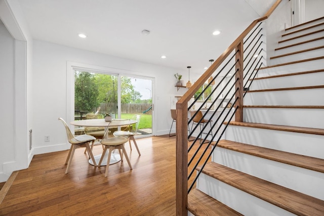 staircase with recessed lighting, wood finished floors, and baseboards