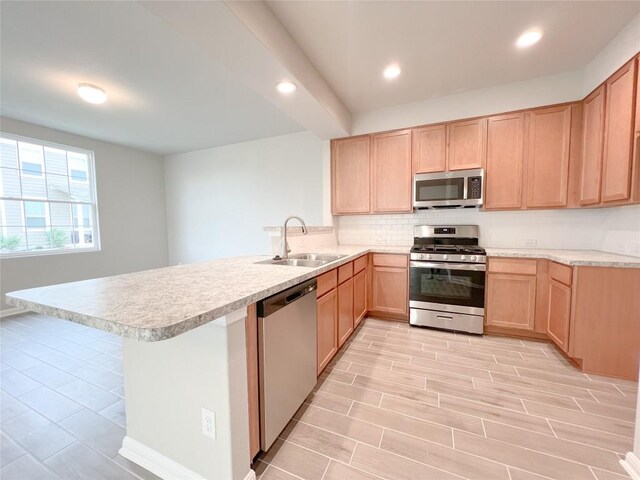 676 Ferrule Dr, Kyle, TX 78640 - kitchen with appliances with stainless steel finishes, a peninsula, a sink, light brown cabinetry, and recessed lighting