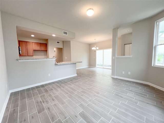 676 Ferrule Dr, Kyle, TX 78640 - unfurnished living room featuring a chandelier, baseboards, healthy amount of natural light, and recessed lighting