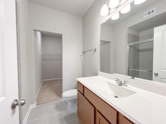 676 Ferrule Dr, Kyle, TX 78640 - bathroom featuring vanity, toilet, a walk in closet, a shower stall, and tile patterned flooring