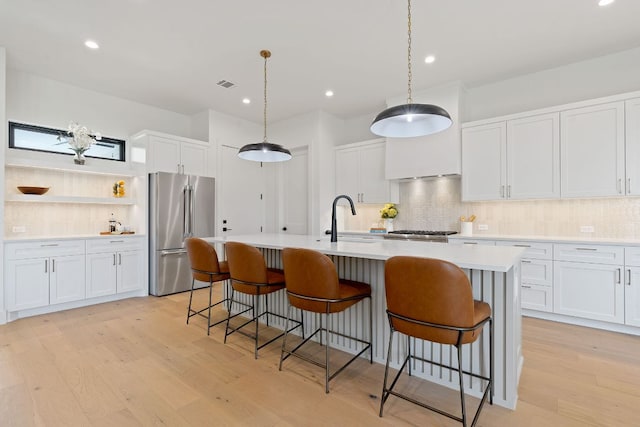 814 Stark St, Austin, TX 78756 - kitchen featuring high end refrigerator, light wood-style flooring, decorative backsplash, a sink, and recessed lighting