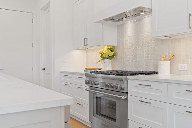 814 Stark St, Austin, TX 78756 - kitchen featuring high end stainless steel range oven, premium range hood, tasteful backsplash, and white cabinetry