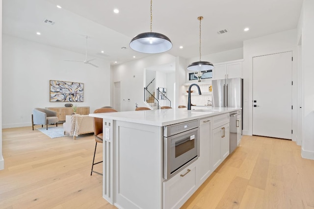 814 Stark St, Austin, TX 78756 - kitchen featuring a sink, white cabinetry, light wood-style floors, open floor plan, and recessed lighting
