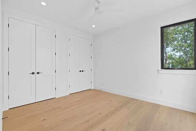 814 Stark St, Austin, TX 78756 - unfurnished bedroom featuring two closets, light wood-style flooring, baseboards, recessed lighting, and a ceiling fan