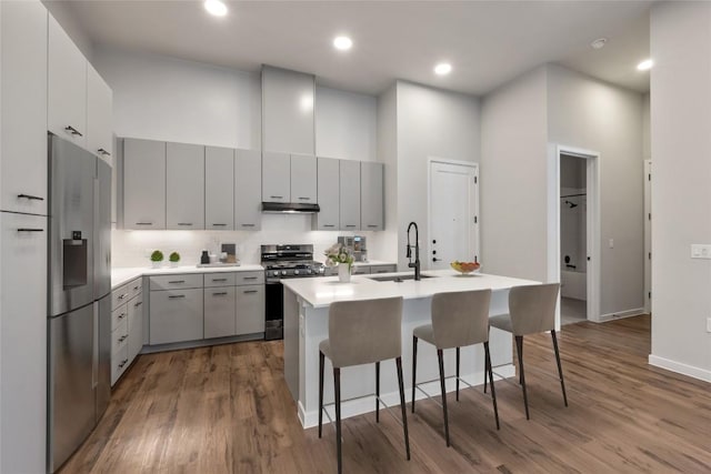 4510 Terry-O Ln Unit 141, Austin, TX 78745 - kitchen featuring stainless steel appliances, under cabinet range hood, gray cabinets, dark wood finished floors, and a high ceiling