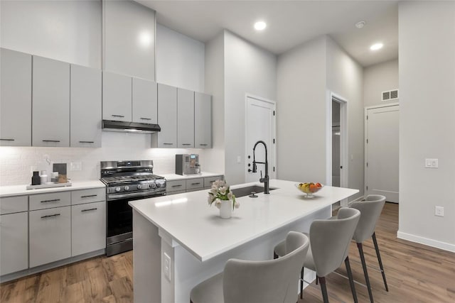 4510 Terry-O Ln Unit 141, Austin, TX 78745 - kitchen with gas range, gray cabinetry, under cabinet range hood, recessed lighting, and a high ceiling