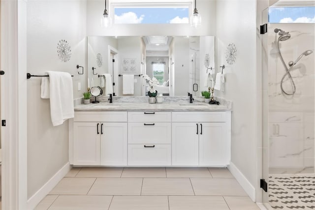 full bath with double vanity, baseboards, a stall shower, and a sink