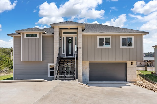 view of front facade featuring a garage, a shingled roof, and driveway