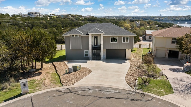 view of front of property with a garage, driveway, and a shingled roof