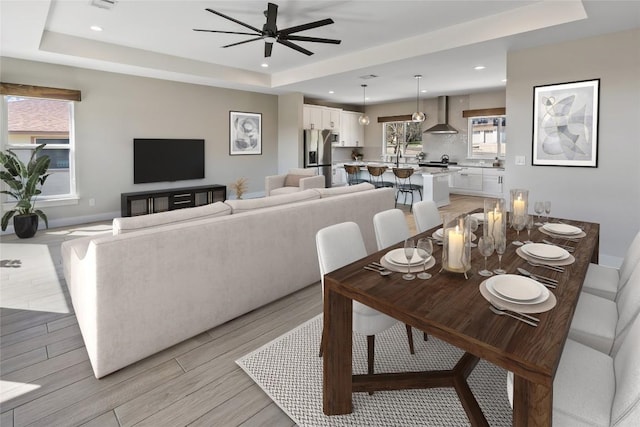 dining space with a ceiling fan, recessed lighting, and a raised ceiling