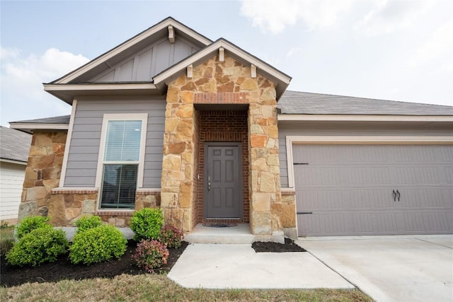 168 Onna St, Taylor, TX 76574 - view of front facade featuring stone siding, a garage, and concrete driveway