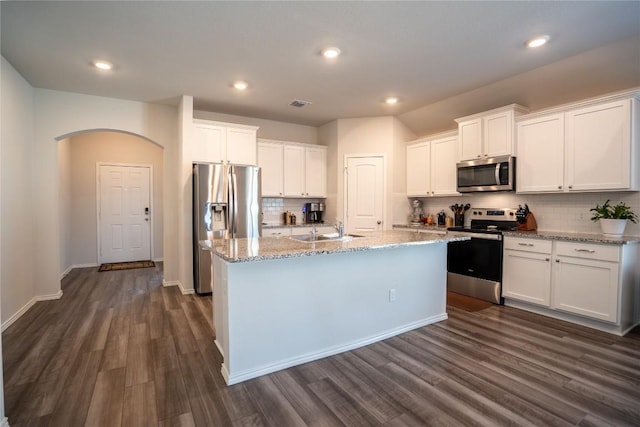 168 Onna St, Taylor, TX 76574 - kitchen featuring appliances with stainless steel finishes, dark wood finished floors, backsplash, white cabinets, and recessed lighting