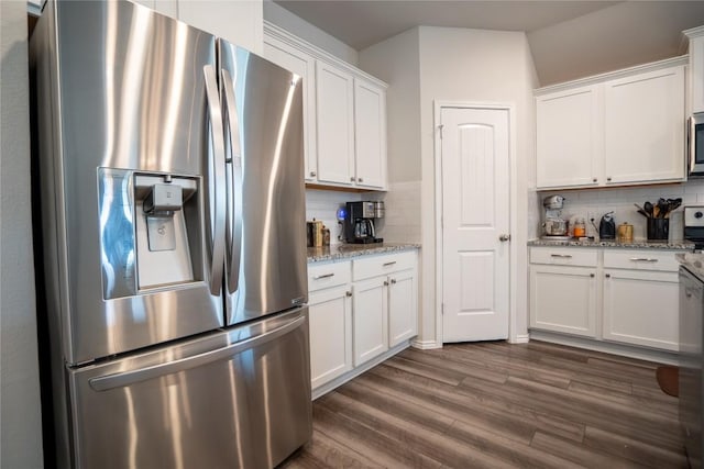 168 Onna St, Taylor, TX 76574 - kitchen with appliances with stainless steel finishes, white cabinetry, tasteful backsplash, and dark wood finished floors