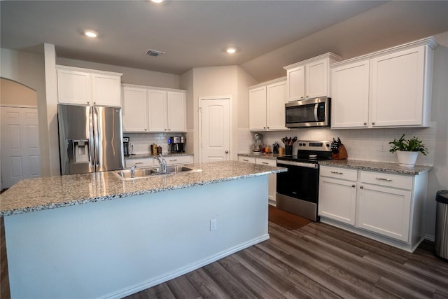 168 Onna St, Taylor, TX 76574 - kitchen with stainless steel appliances, decorative backsplash, an island with sink, dark wood finished floors, and white cabinets