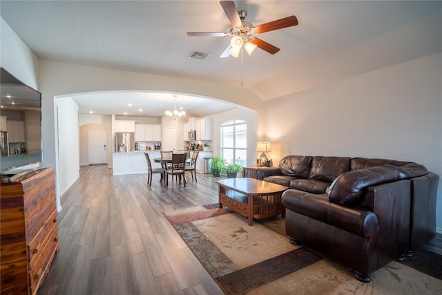 168 Onna St, Taylor, TX 76574 - living area with arched walkways, wood finished floors, a ceiling fan, vaulted ceiling, and a chandelier