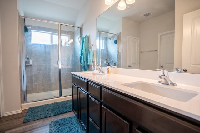 168 Onna St, Taylor, TX 76574 - full bath featuring a stall shower, double vanity, and wood finished floors