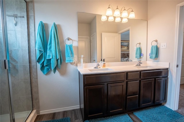 168 Onna St, Taylor, TX 76574 - full bathroom featuring a stall shower, double vanity, wood finished floors, and a chandelier