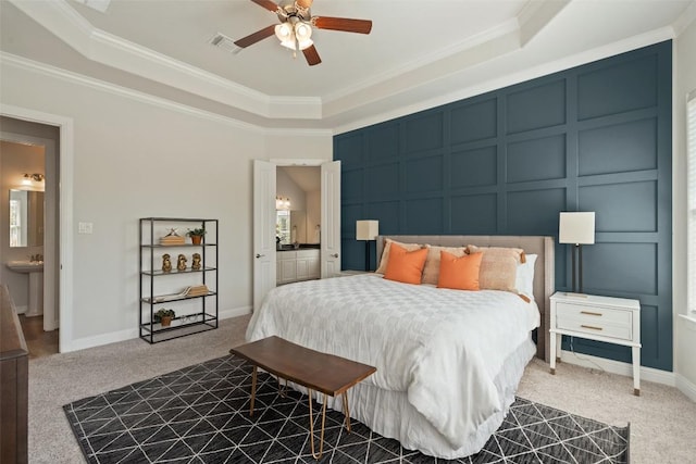 306 Gulfton St, Austin, TX 78738 - carpeted bedroom featuring a decorative wall, a tray ceiling, crown molding, ensuite bath, and a ceiling fan